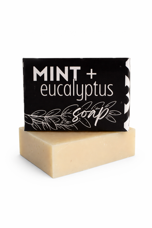 Bar of soap with a black label reading 'Mint + Eucalyptus Soap' on a white background.